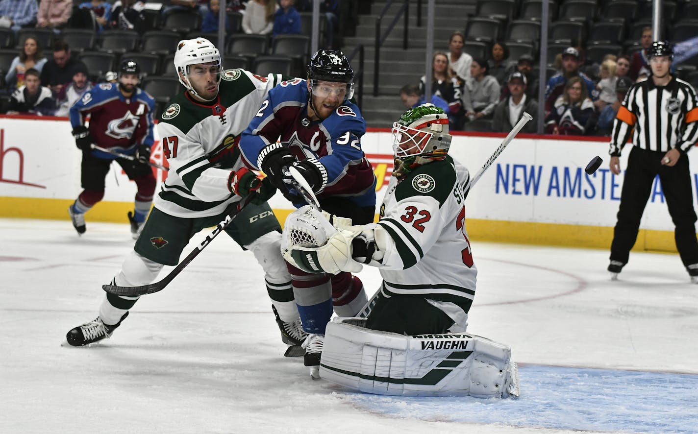 Colorado Avalanche left wing Gabriel Landeskog (92) gets pressure from Minnesota Wild's Louie Belpedio (47) as he deflects the puck past Wild goaltender Alex Stalock (32) during the first period in an NHL preseason hockey game Sunday, Sept. 22, 2019 in Denver (AP Photo/John Leyba)