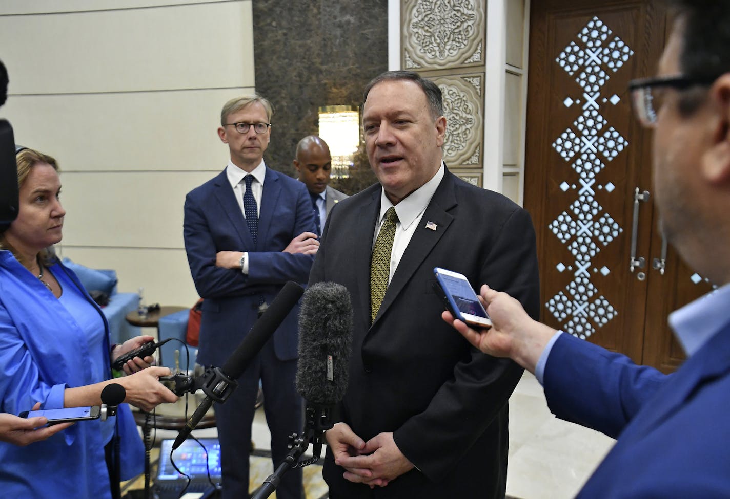 U.S. Secretary of State Mike Pompeo speaks to the media before departing from al-Bateen Air Base in Abu Dhabi, United Arab Emirates, Thursday, Sept. 19, 2019, as U.S. special representative on Iran Brian Hook, second from left, listens. (Mandel Ngan/Pool via AP)