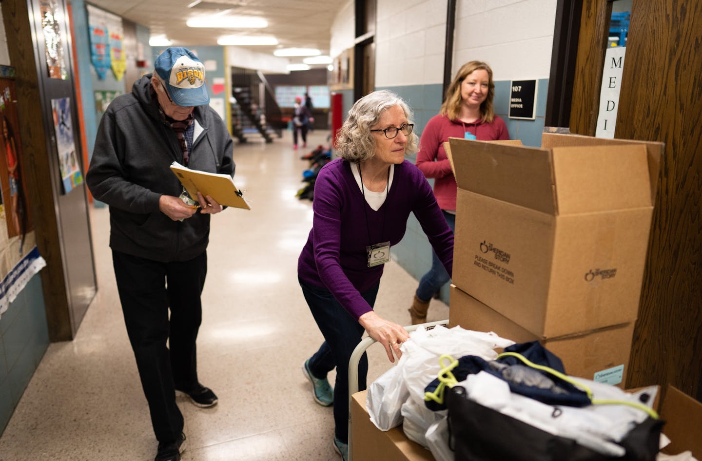 Volunteers John and Sharon Eian wheeled boxes of donations between classrooms. Their church, Lynnhurst Congregational Church, is paired with this specific school, where they volunteer about once a month.