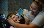 From left, Tara Carlson laughed while Sam Blanks, both of Blaine, put a newly crafted headband on her forehead. The Minnesota State Council on Disabil