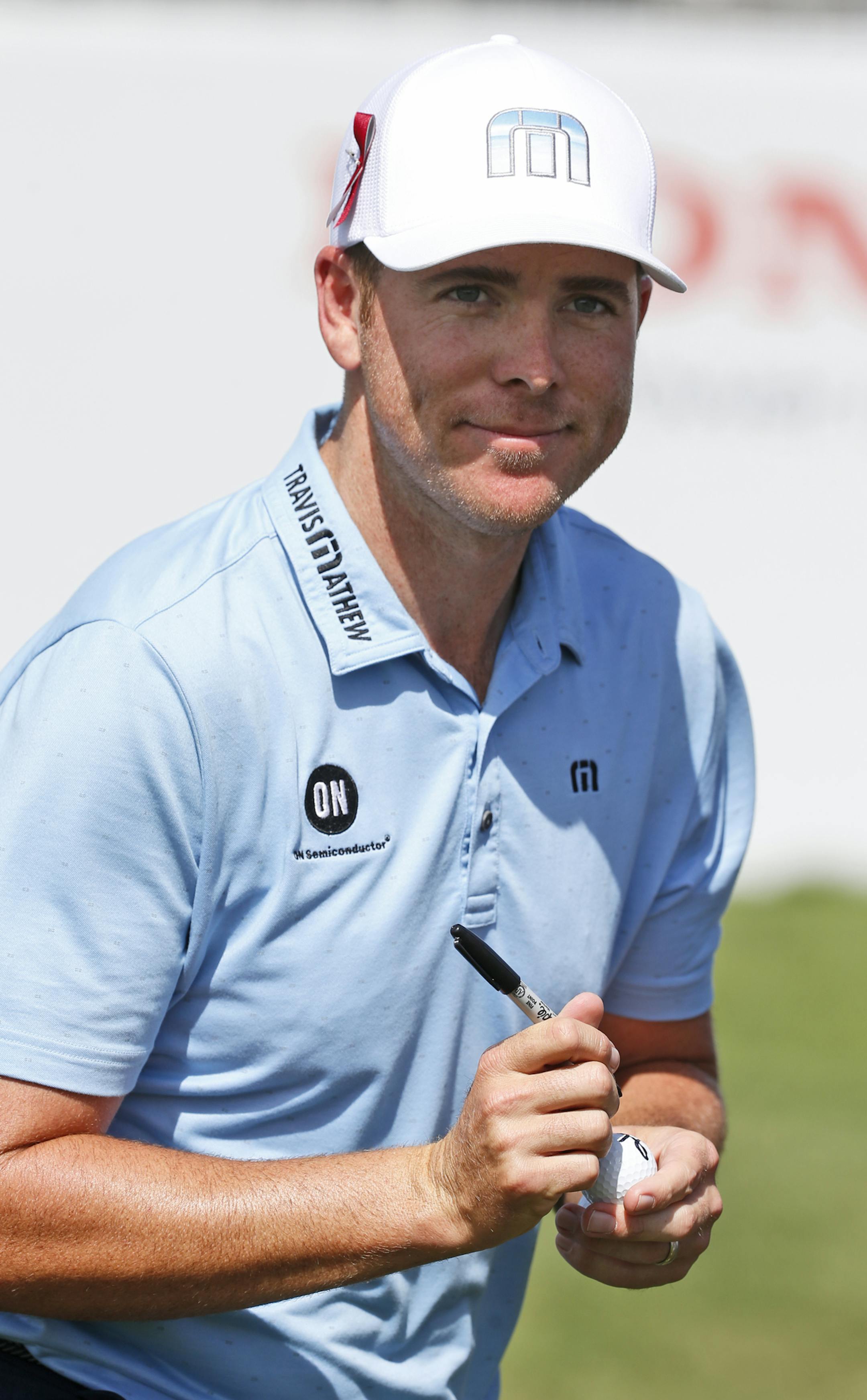 Luke List autographs a golf ball after finishing the second round of the Honda Classic golf tournament, Friday, Feb. 23, 2018 in Palm Beach Gardens, Fla. (AP Photo/Wilfredo Lee)