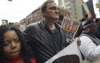 Director Quentin Tarantino, center, participates in a rally to protest against police brutality Saturday, Oct. 24, 2015, in New York. Speakers at the 