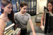 Maia,14, and Erin,16, Erbes check out library books at the Burnhaven Library in Burnsville with their mom, Lisa Erbes. Teens now have the chance to us