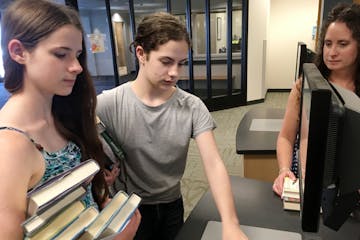 Maia,14, and Erin,16, Erbes check out library books at the Burnhaven Library in Burnsville with their mom, Lisa Erbes. Teens now have the chance to us