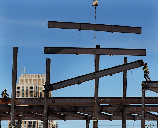 A construction worker, with the help of a crane, guides steel beams into place on the new Thrivent Financial building April 3, 2019, in Minneapolis. O