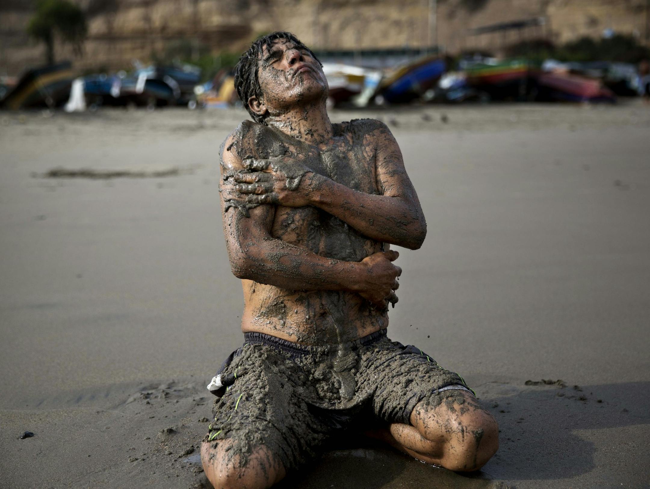 In this May 14, 2015 photo, Berto Nestaris covers his body with sand on Fishermen's Beach in Lima, Peru. Berto, a 55-year-old sociologist, said therapeutic massages using sea sand helps his circulation and nervous system.