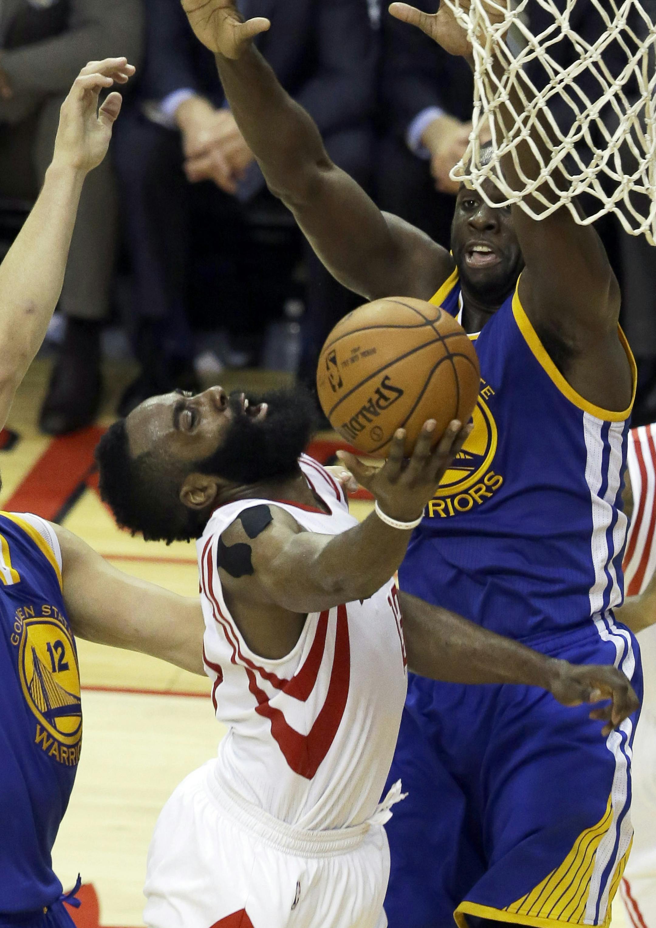 Houston Rockets guard James Harden (13) shoots as Golden State Warriors center Andrew Bogut (12) and forward Draymond Green (23) defend during the second half in Game 4 of the NBA basketball Western Conference finals Monday, May 25, 2015, in Houston. (AP Photo/Pat Sullivan)