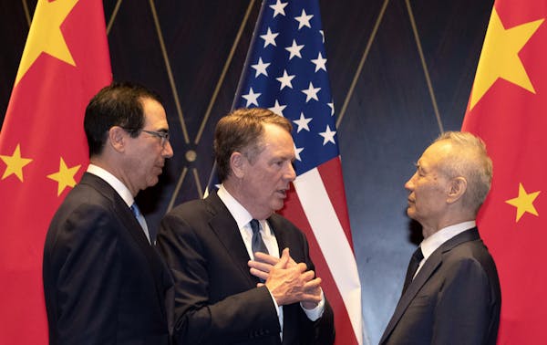 FILE - In this July 31, 2019, file photo U.S. Trade Representative Robert Lighthizer, center, gestures as he chats with Chinese Vice Premier Liu He, a