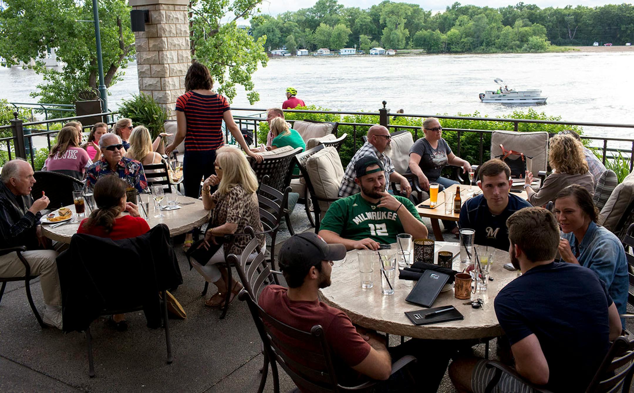 Diners sit along the patio at The Waterfront Restaurant & Tavern with a view of the Mississippi River. ] COURTNEY PEDROZA • courtney.pedroza@startribune.com June 22-24, 2017; Wisconsin restaurants, cafes, bars, bakeries and breweries; Dining along the Mississippi River.