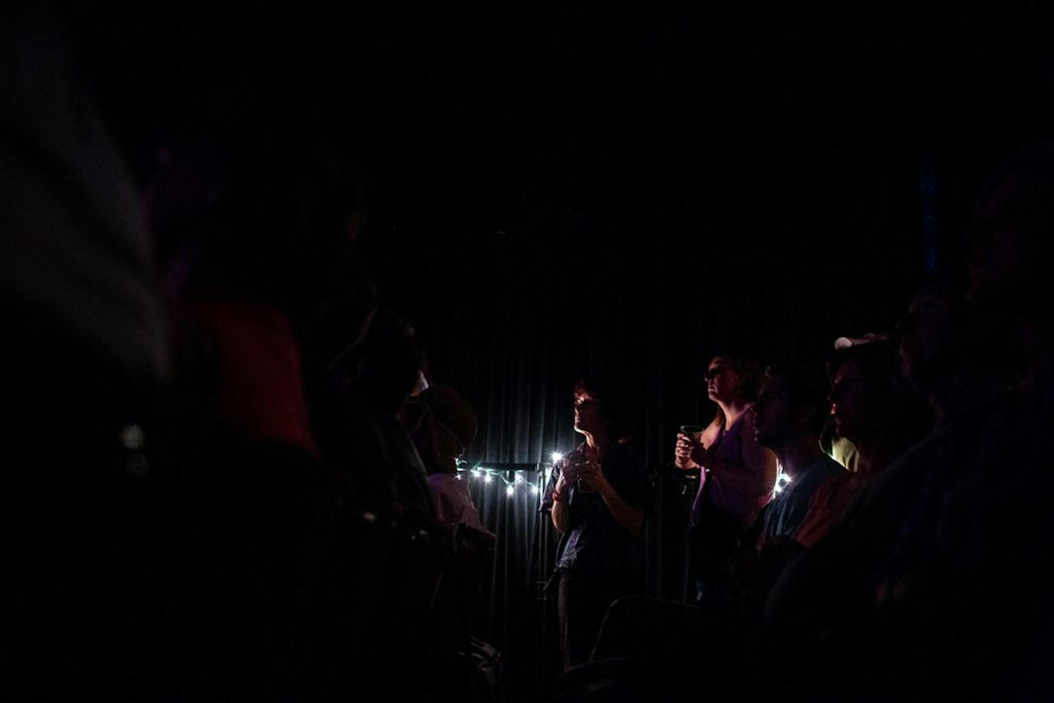 Audience members listen to The Peterson Brothers perform at the KFAI Theater Stage.