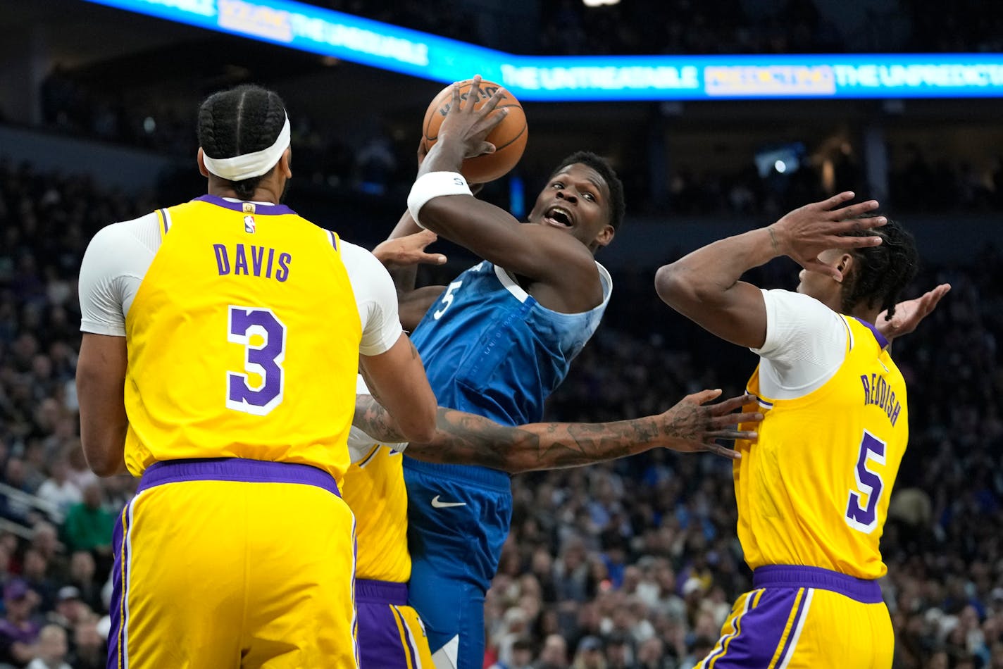 Minnesota Timberwolves guard Anthony Edwards, center, works toward the basket as Los Angeles Lakers forwards Anthony Davis (3) and Cam Reddish (5) defend during the first half of an NBA basketball game, Thursday, Dec. 21, 2023, in Minneapolis. (AP Photo/Abbie Parr) ORG XMIT: MNAP203