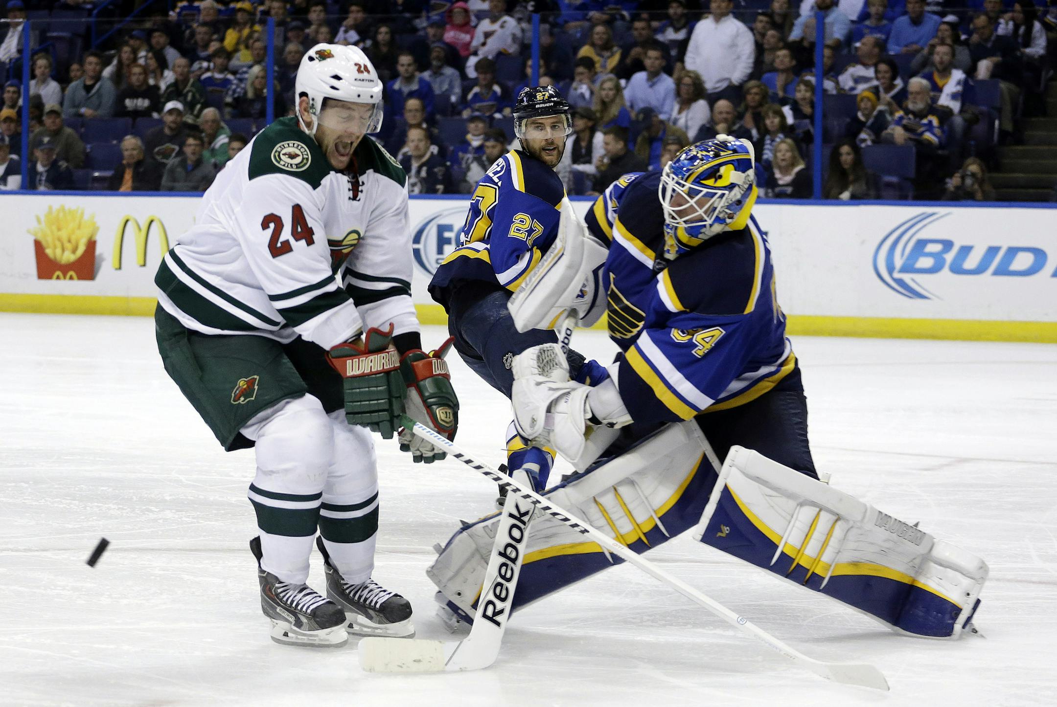 St. Louis Blues goalie Jake Allen, right, comes way out of position to knock a puck away from Minnesota Wild's Matt Cooke during the third period in Game 5 of an NHL hockey first-round playoff series, Friday, April 24, 2015, in St. Louis. The Wild won 4-1. (AP Photo/Jeff Roberson)