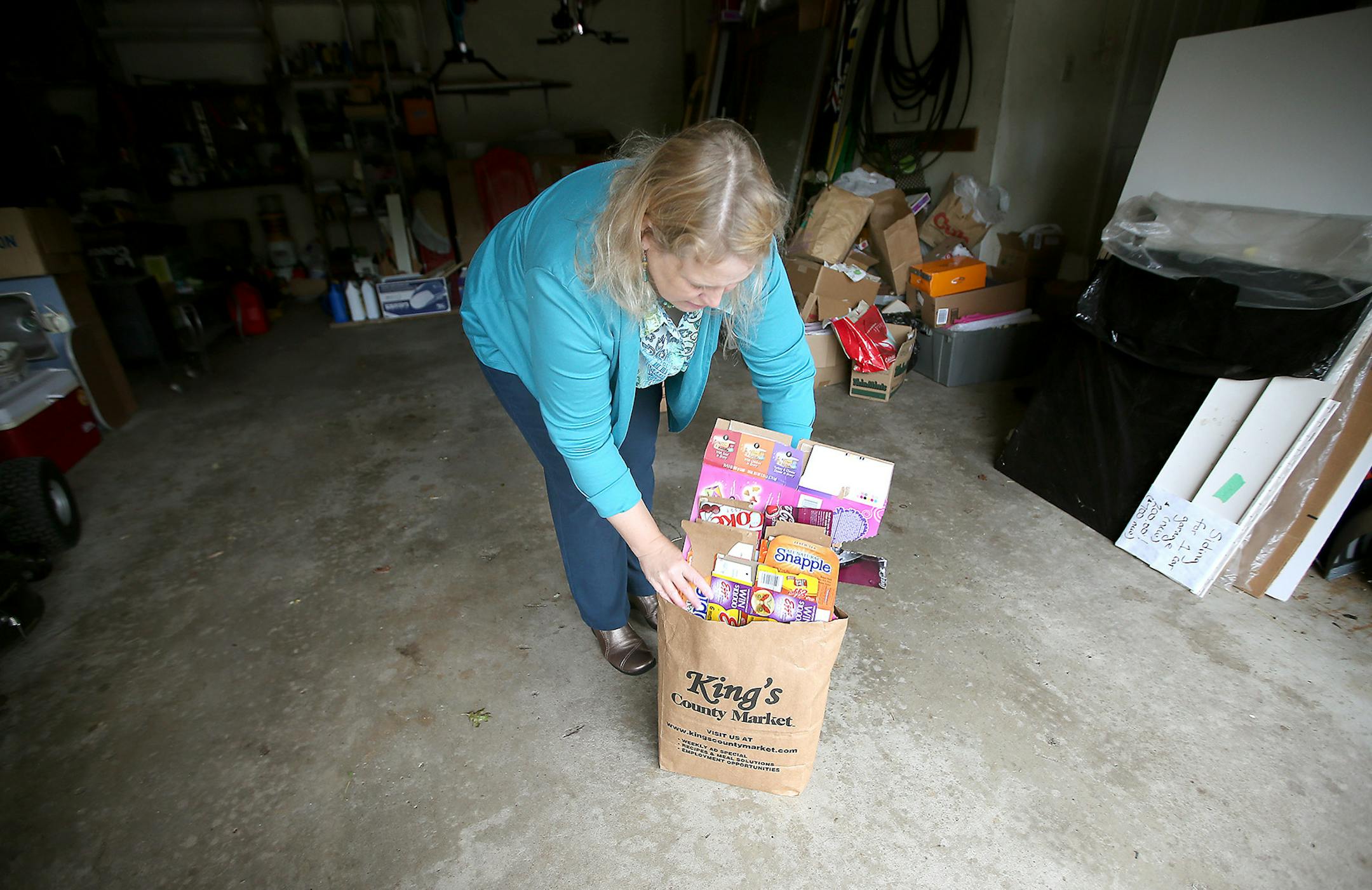 Sue Doll gathered wet strength products into a paper bag to add to her recycling Wednesday, September 10, 2014 in Andover, MN. ] (ELIZABETH FLORES/STAR TRIBUNE) ELIZABETH FLORES • eflores@startribune.com