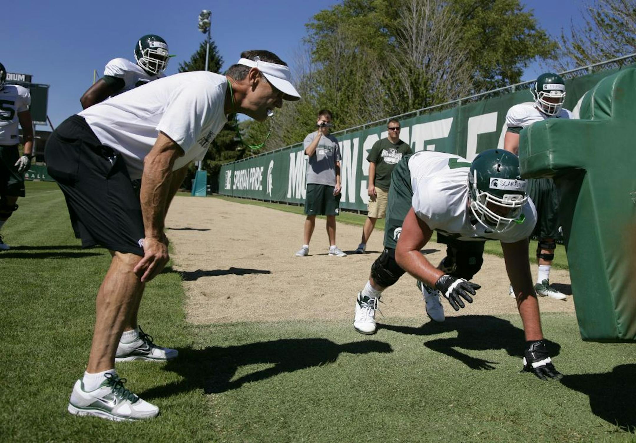 While offense is all the rage, Michigan State coach Mark Dantonio, left, is true to his defensive roots. "He's one of us," linebacker Max Bullough said. "Sometimes all you read about is offensive [geniuses], doing new things to score. You don't hear much about coaches who preach defense."