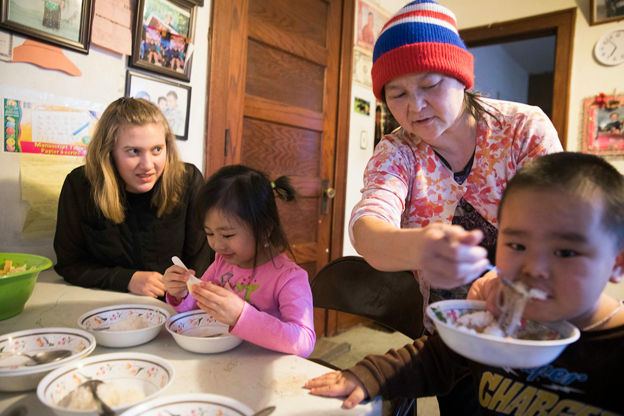 Minnehaha Academy student Abbi Slininger, from left, 15, eats a traditional Hmong dinner that she helped cook with Jane Lee, 5, Jayden Lee, 3, and their grandmother Xai Lee.] LEILA NAVIDI ï leila.navidi@startribune.com BACKGROUND INFORMATION: in St Paul on Wednesday, March 15, 2017. City Stay is an opportunity for Minnesota high school students to do home stays at the homes of other local residents. The cultural exchange program fosters new relationships among Minnesota's European, Latin America