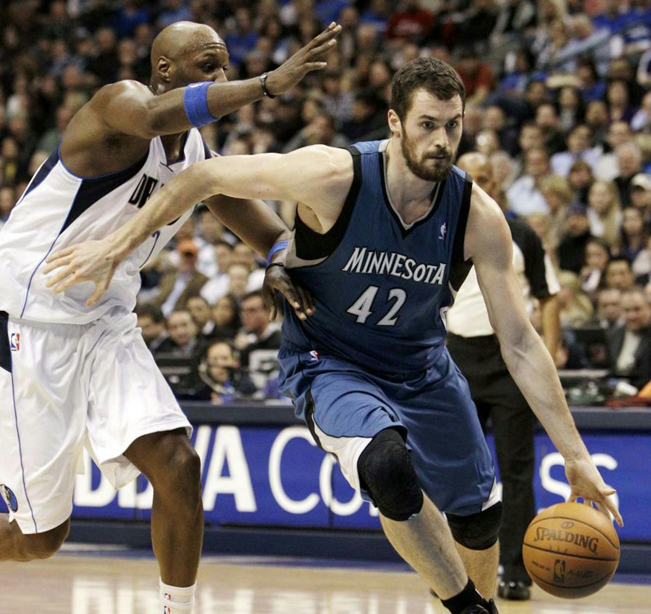Wolves forward Kevin Love, who earlier Wednesday signed a four-year contract extension worth about $61 million, drove past the Mavericks' Lamar Odom in the first half of the Wolves' 105-90 victory.