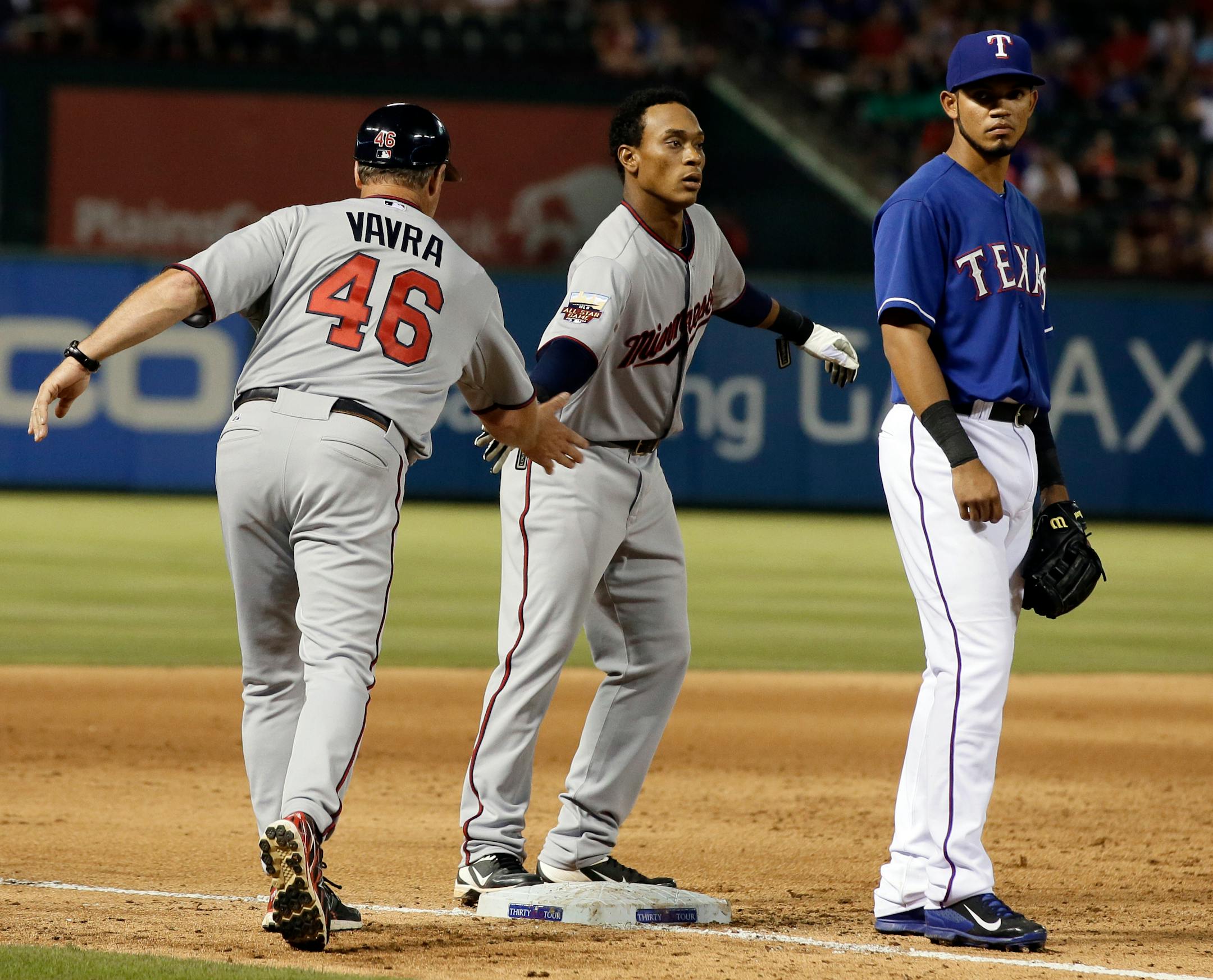 Twins third base coach Joe Vavra congratulated Jorge Polanco on his two-run triple on Friday against Texas.