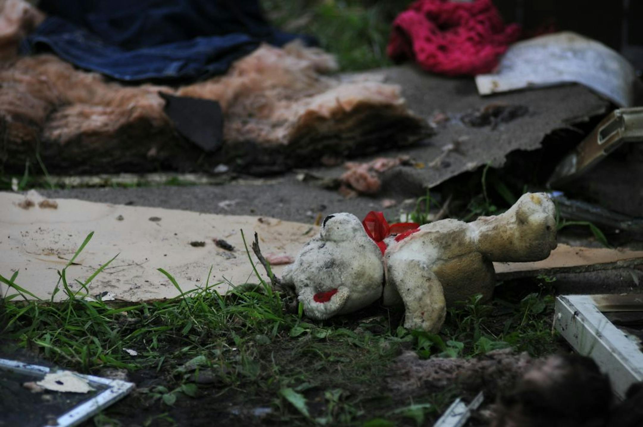 Wreckage could be seen strewn about the yard including a teddy bear at the site where two people were severely burned after an explosion caused a house fire July 30, 2011 at a small home in North Minneapolis.