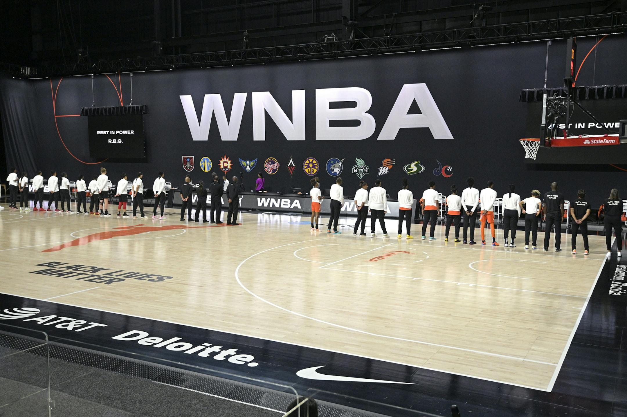 Members of the Las Vegas Aces, left, and the Connecticut Sun stand in honor of the passing of Supreme Court Justice Ruth Bader Ginsburg before Game 1 of a WNBA basketball semifinal round playoff game, Sunday, Sept. 20, 2020, in Bradenton, Fla. (AP Photo/Phelan M. Ebenhack)