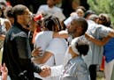 FILE -- Pastor Danny Givens, front right, shakes hands with a mourner following a celebration of life service for Le'Vonte King Jason Jones, 2, shot a