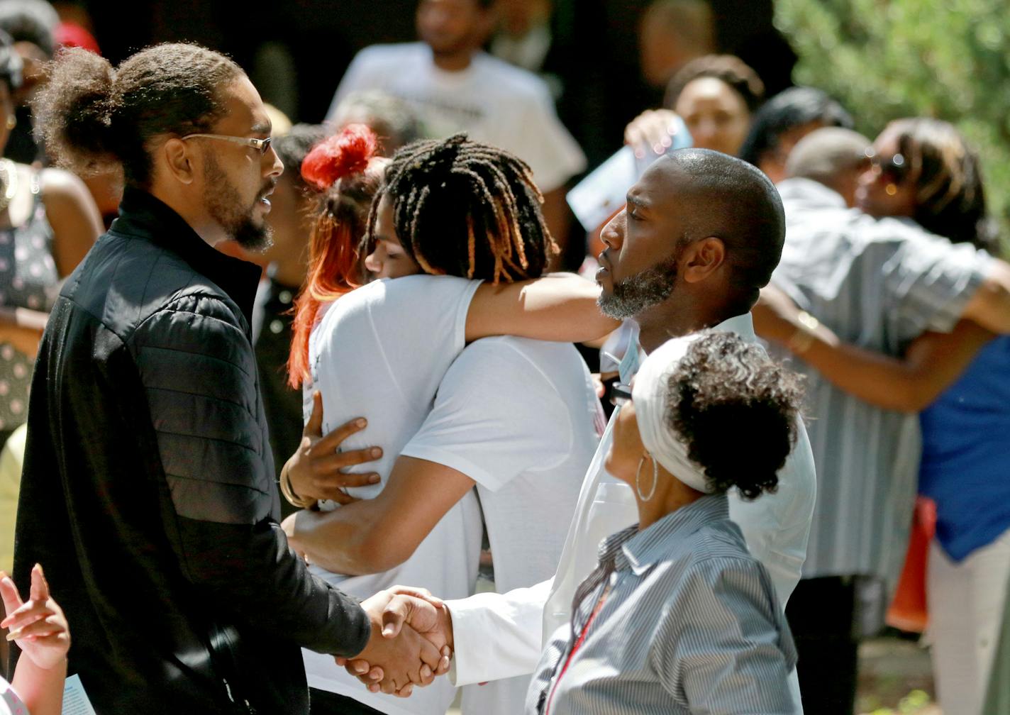 FILE -- Pastor Danny Givens, front right, shakes hands with a mourner following a celebration of life service for Le'Vonte King Jason Jones, 2, shot and killed last week in a drive-by shooting,