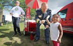 Mayor Chris Coleman laughed as he watched new St. Paul Police Chief Todd Axtell make children happy including Demeliah Britton, 2, cq, as they handed 