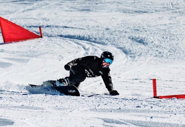 G Team senior snowboarder Jacob McCarthy carves down a hill during an Alpine snowboarding race.