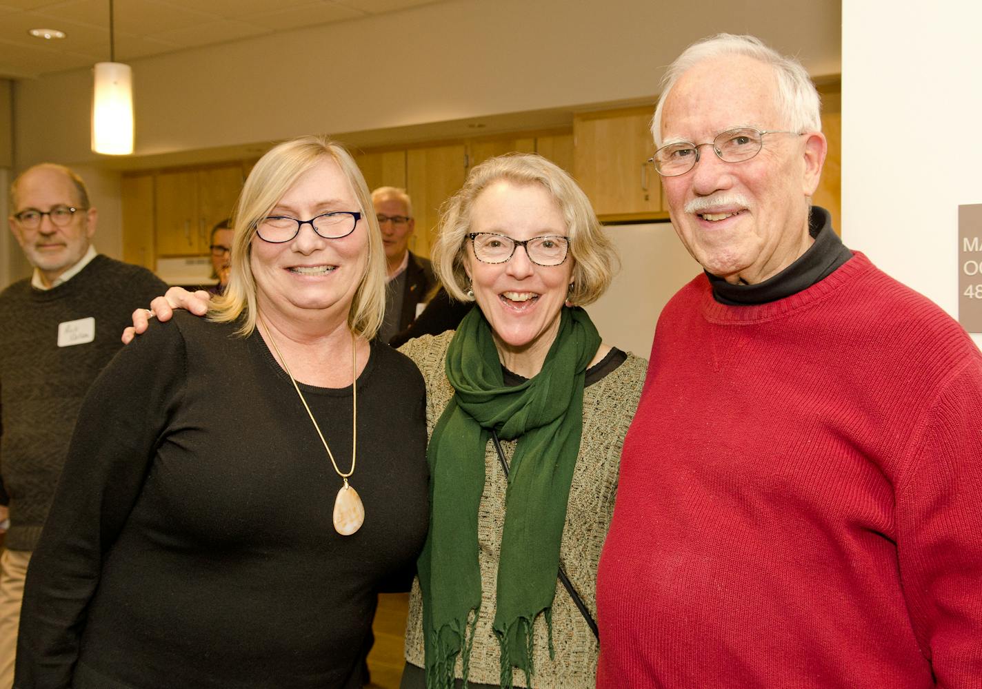 Jana Bonner, left, a disabled fromer business woman who ended up homeless in 2017, joined 43 other formerly homeless folks, 55 and older, in their new new studio apartments at Minnehaha Commons, developed by nonprofit Alliance Housing on E. Lake Street this fall. She is pictured with Alliance Housing CEO Barbara Jeanetta and volunteer Ted Pouliot in the kitchen of Minnehaha Commons. Photo: Paula Keller