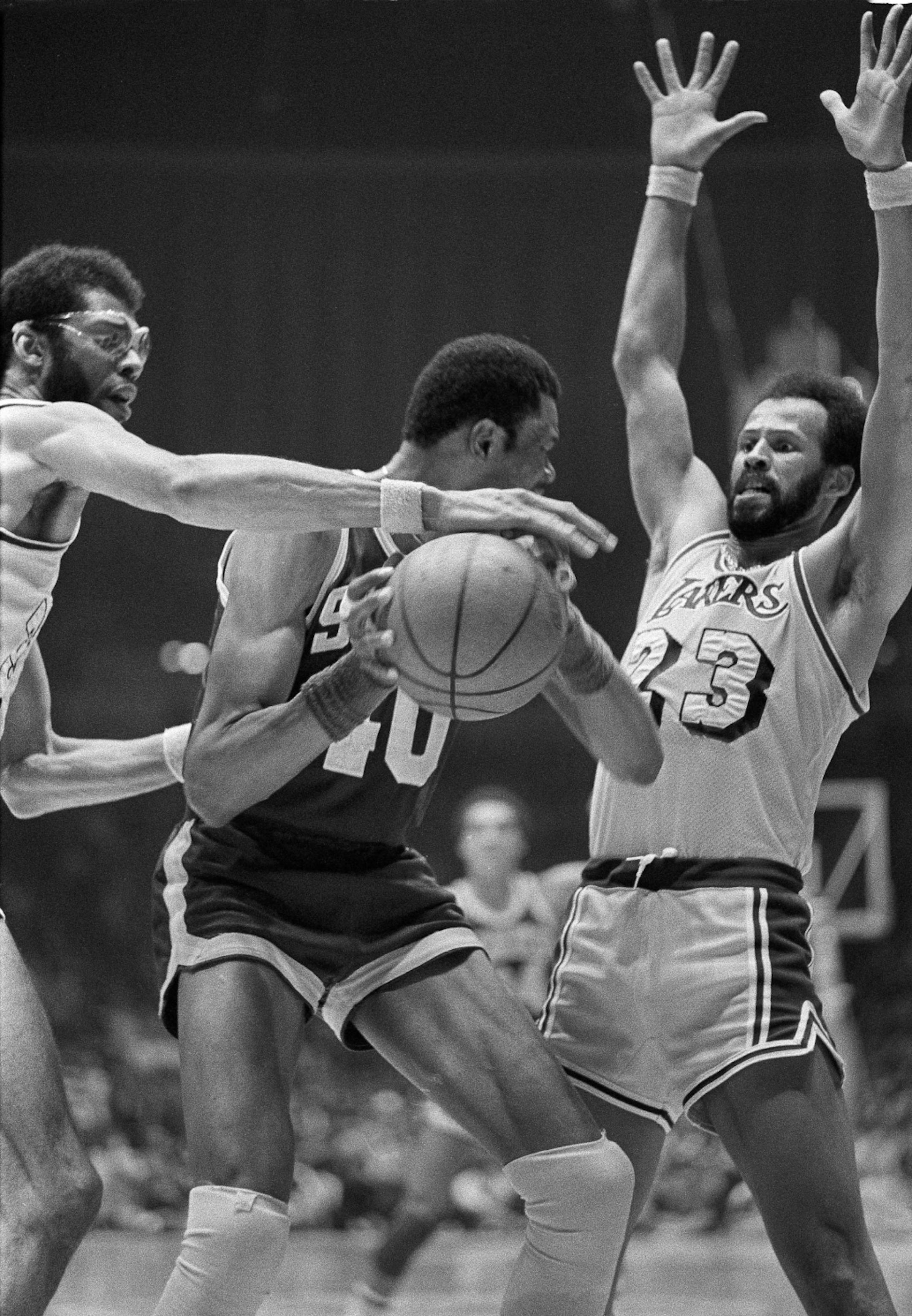 FILE - In this April 15, 1978 file photo, Los Angeles Lakers' Kareem Abdul-Jabbar, left, reaches for the ball held by Seattle Supersonics Marvin Webster, center, as Lakers' Lou Hudson (23), right, defends during an NBA playoff game in Los Angeles. Six-time All-Star Lou Hudson died Friday, April 11, 2014, in Atlanta, the Atlanta Hawks said. He was 69.