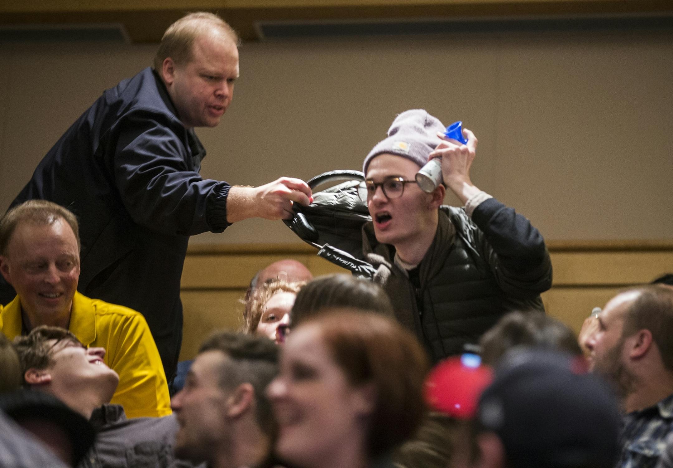 A protester interrupts with a blow horn and is escorted out during a talk by Milo Yiannopoulos and Christina Hoff Sommers at the Humphrey Institute of Public Affairs on the campus of the University of Minnesota in Minneapolis on Wednesday, February 17, 2016.