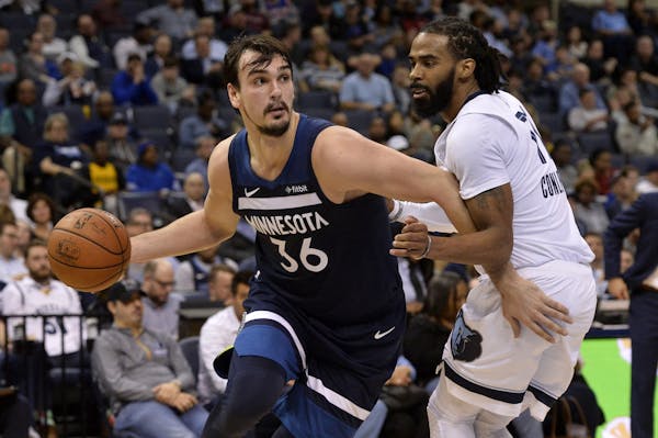 Minnesota Timberwolves forward Dario Saric, left, drives against Memphis Grizzlies guard Mike Conley, right, in the first half of an NBA basketball ga