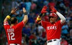 The Rangers' Rougned Odor (12) congratulated Ronald Guzman (67) after Guzman's three-run home run against the Twins during the second inning.