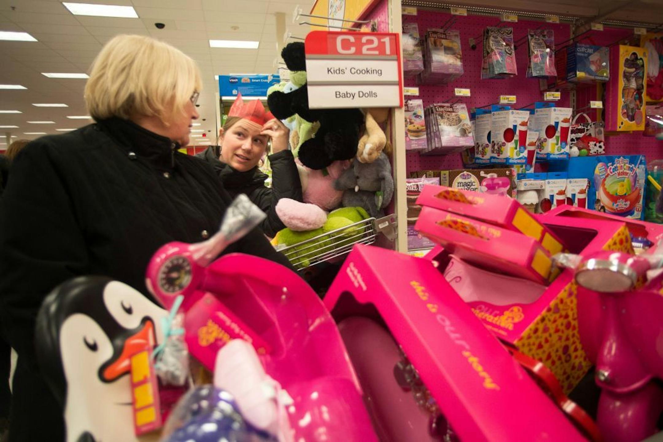 Lynn Schneider, left, and Brandi Herzog discuss buying American Girl dolls for Herzog's daughters while shopping at Super Target in Roseville on Thanksgiving night.