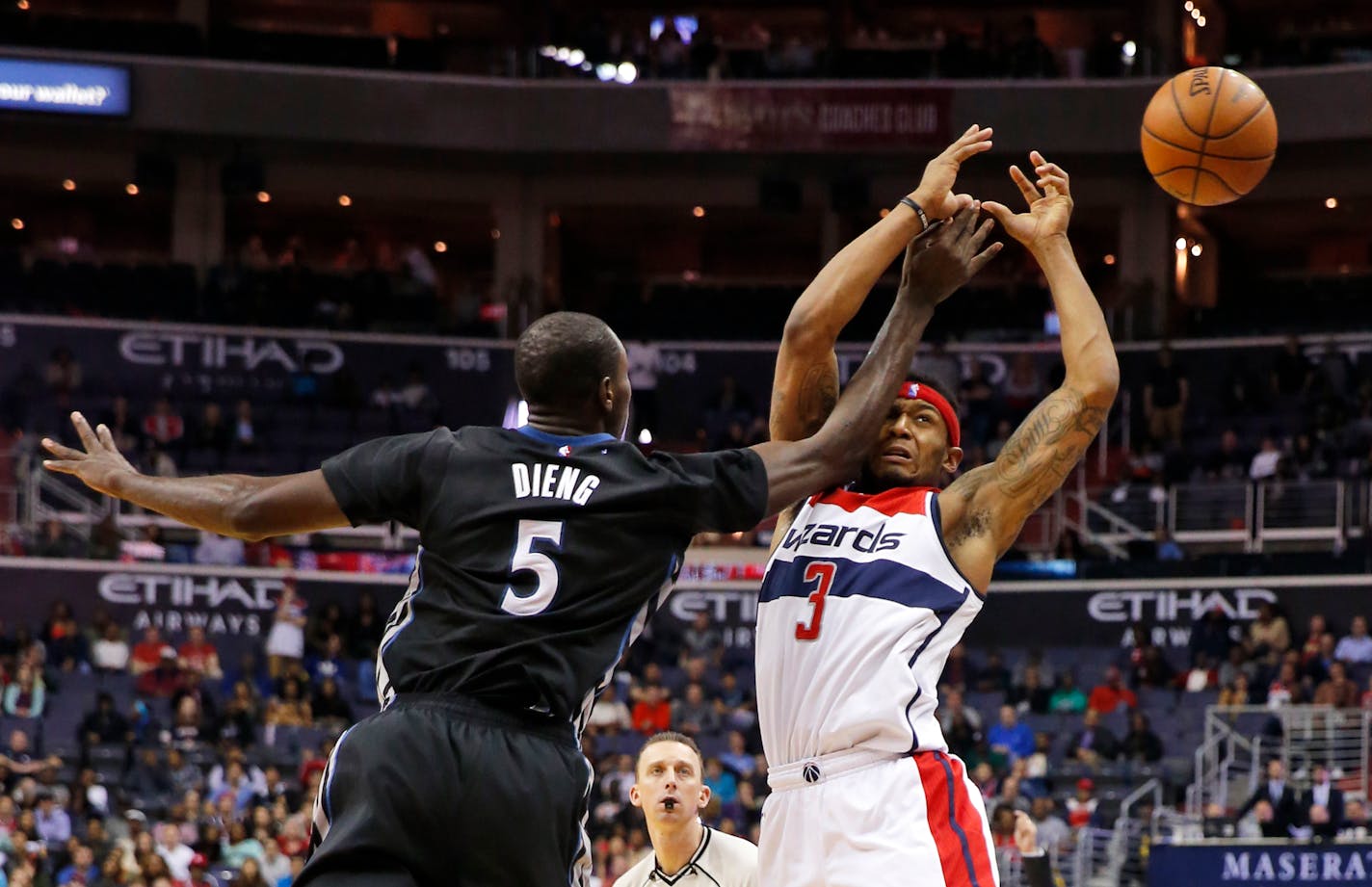 Minnesota Timberwolves center Gorgui Dieng (5) fouls Washington Wizards guard Bradley Beal during the second overtime of an NBA basketball game Friday, March 25, 2016, in Washington. The Timberwolves won 132-129. (AP Photo/Alex Brandon)