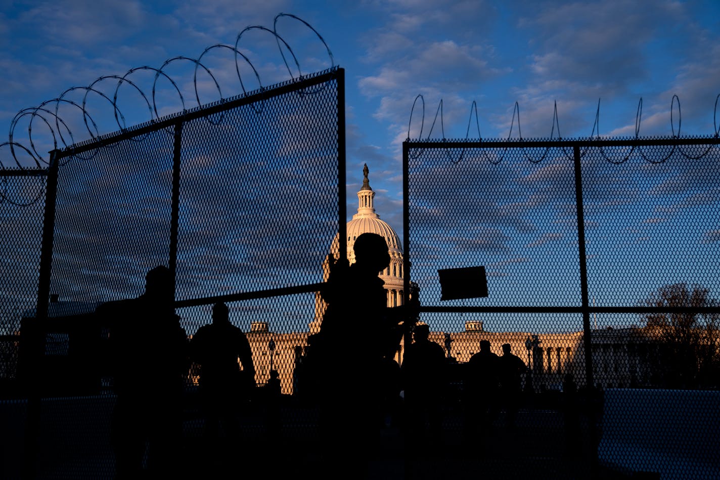 A member of the National Guard closed a section of security fencing outside the Capitol in Washington, on Saturday, Jan. 16, 2021. Federal officials have already concluded that the swearing-in next week of President-elect Joe Biden is a likely target for armed extremists and are expected to flood Washington with more than 20,000 members of the National Guard from 13 states. (Stefani Reynolds/The New York Times)