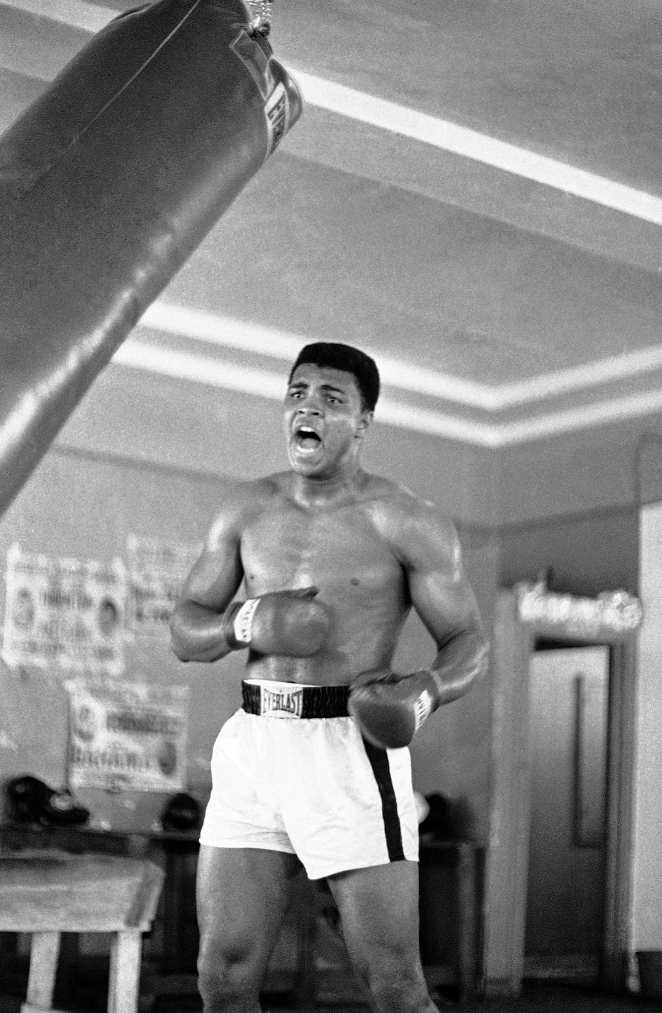 Muhammad Ali (Cassius Clay) punches the heavy bag in one of his daily workouts at Miami Beach for the Feb. 25 championship bout with heavyweight Sonny Liston in Miami Beach, Fla., on Jan. 10, 1964. (AP Photo) ORG XMIT: APHS282041