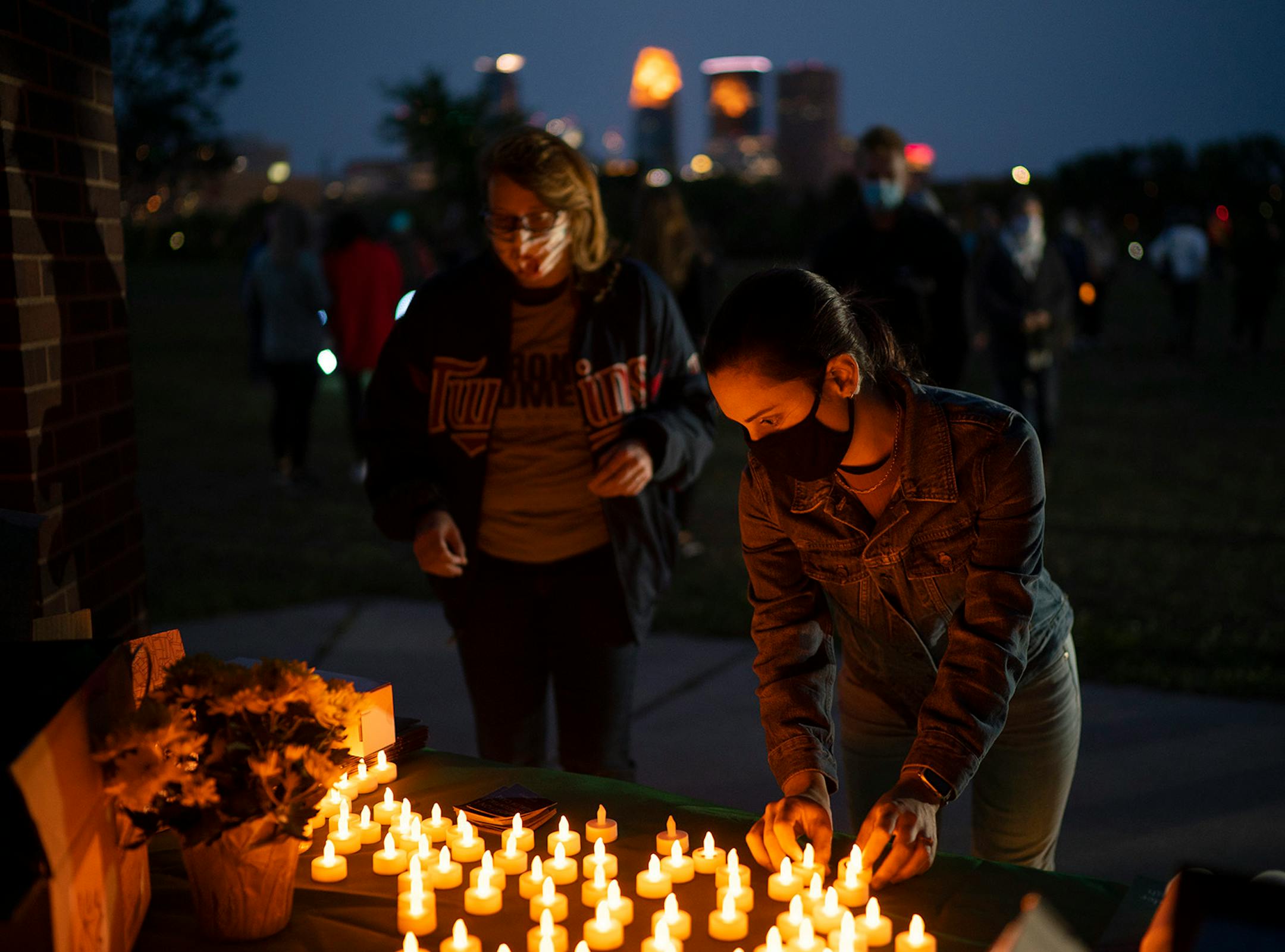 People picked up electric votive candles from a table before the program began.