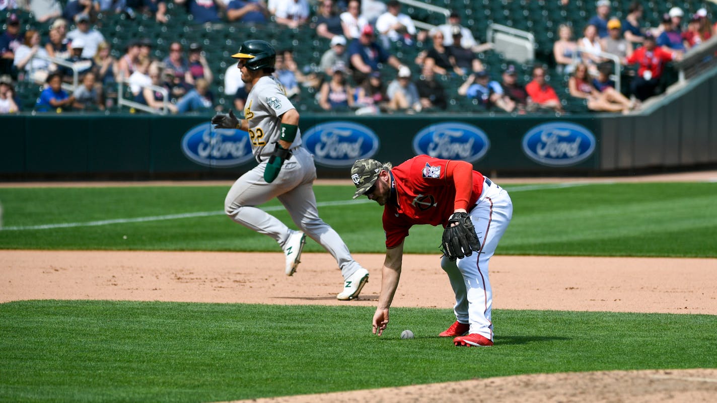 Minnesota Twins third baseman Josh Donaldson, right,&nbsp;mishandles a ground ball, allowing Oakland Athletics' Ramon Laureano (22) to advance to third and Seth Brown to score, during the seventh inning of a baseball game, Sunday, May 16, 2021, in Minneapolis. (AP Photo/Craig Lassig)