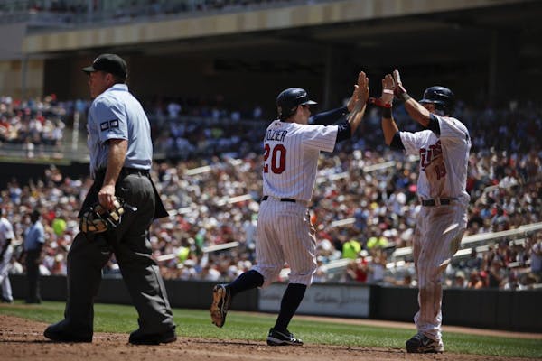 During the Kansas City Royals vs. Minnesota Twins home game (game one), short stop Brian Dozier celebrates his run with catcher Ryan Doumit in the fif