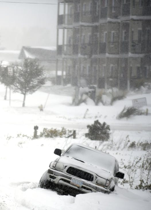 An abandoned SUV is stuck in a snow-filled ditch after the driver slipped off the road near the intersection of North 19th Street and 43rd Ave NE, Friday, Oct. 11, 2019 in Bismarck, N.D. 