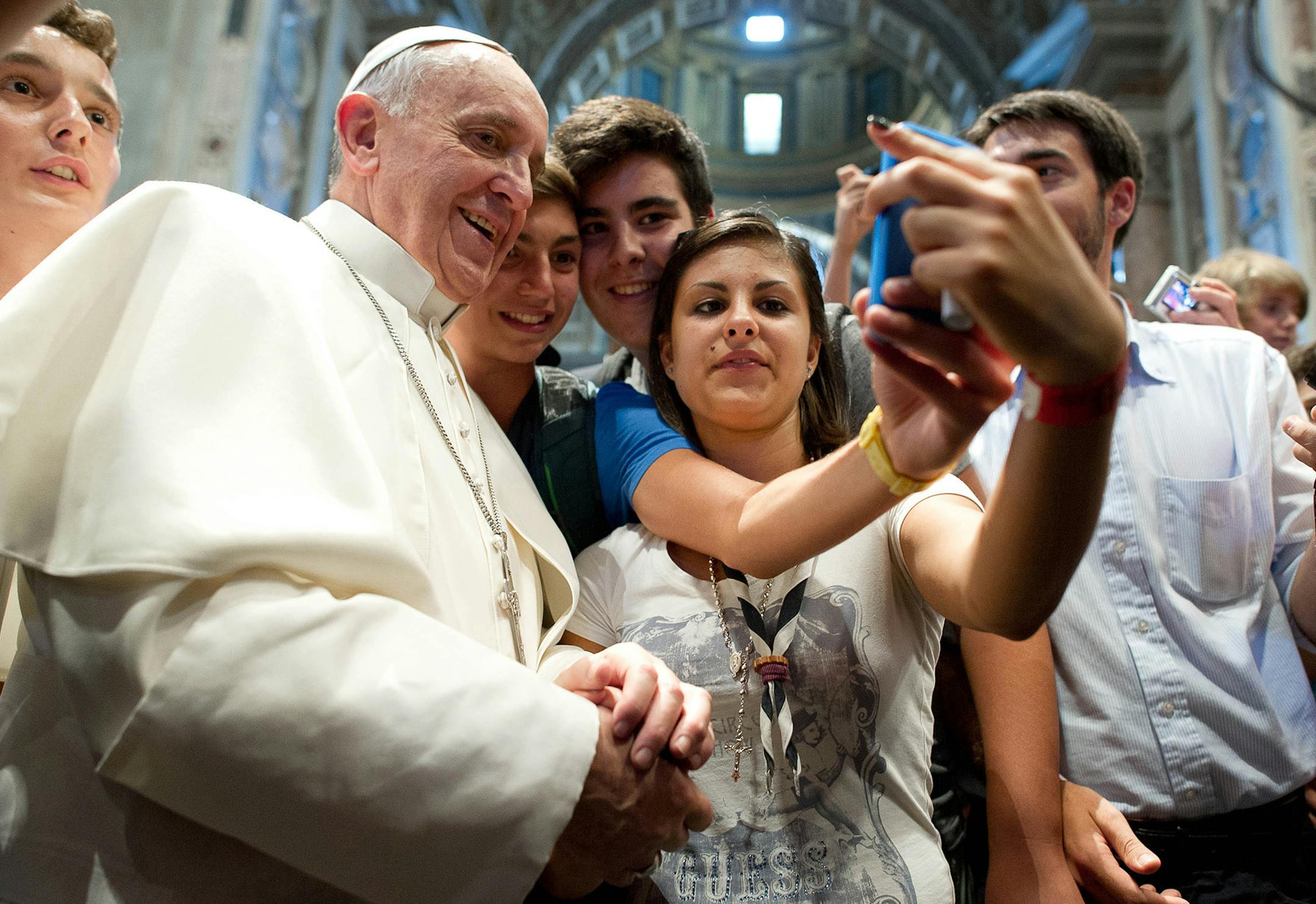 FILE - In this file photo Wednesday, Aug. 28, 2013 Pope Francis has his picture taken inside St. Peter's Basilica with youths from the Italian Diocese of Piacenza and Bobbio who came to Rome for a pilgrimage, at the Vatican.