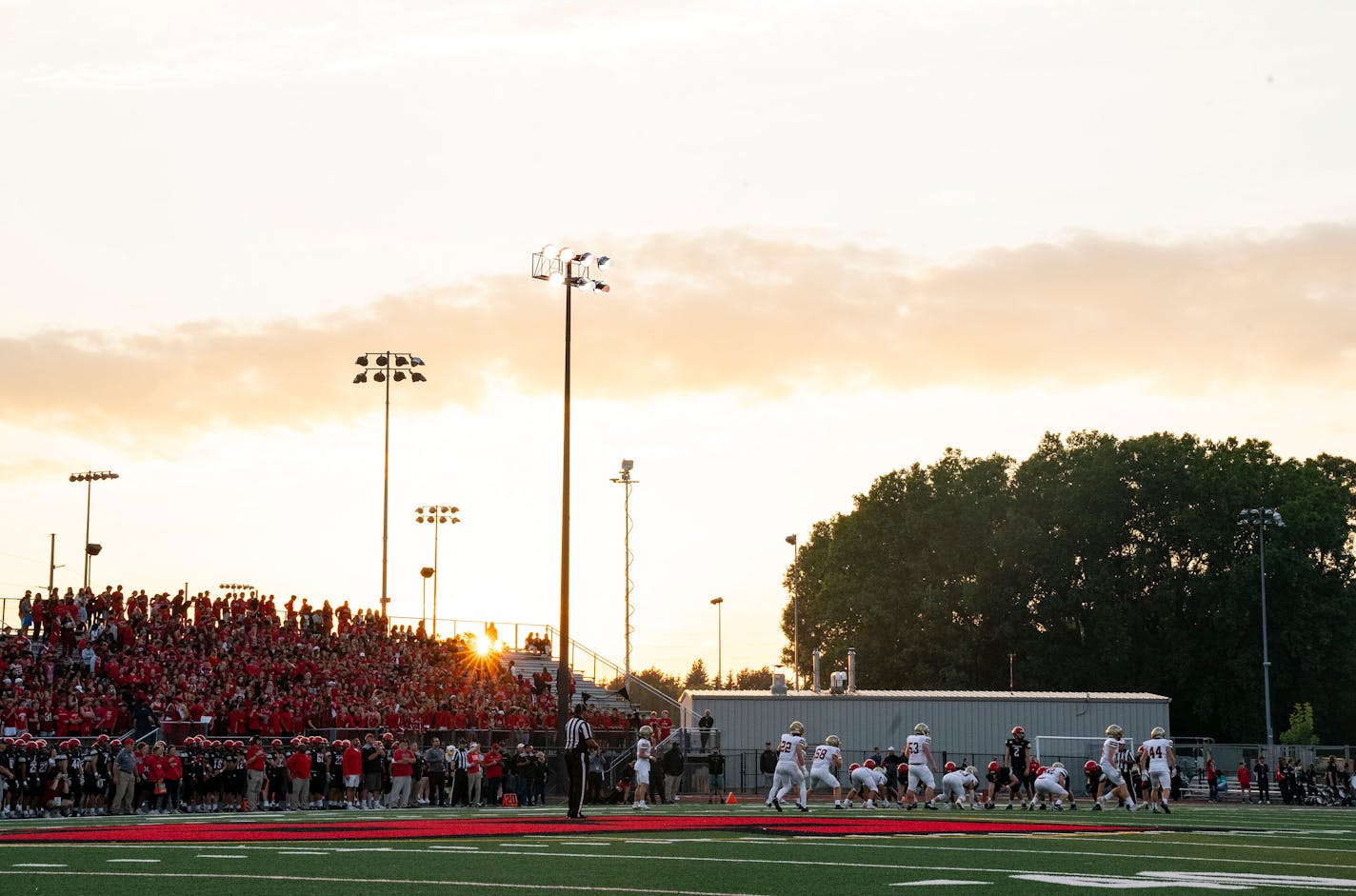 The sun sets as the Eden Prairie football team takes on Lakeville South in the first quarter Friday, September 16, 2022 at Eden Prairie High School in Eden Prairie, Minn. ]