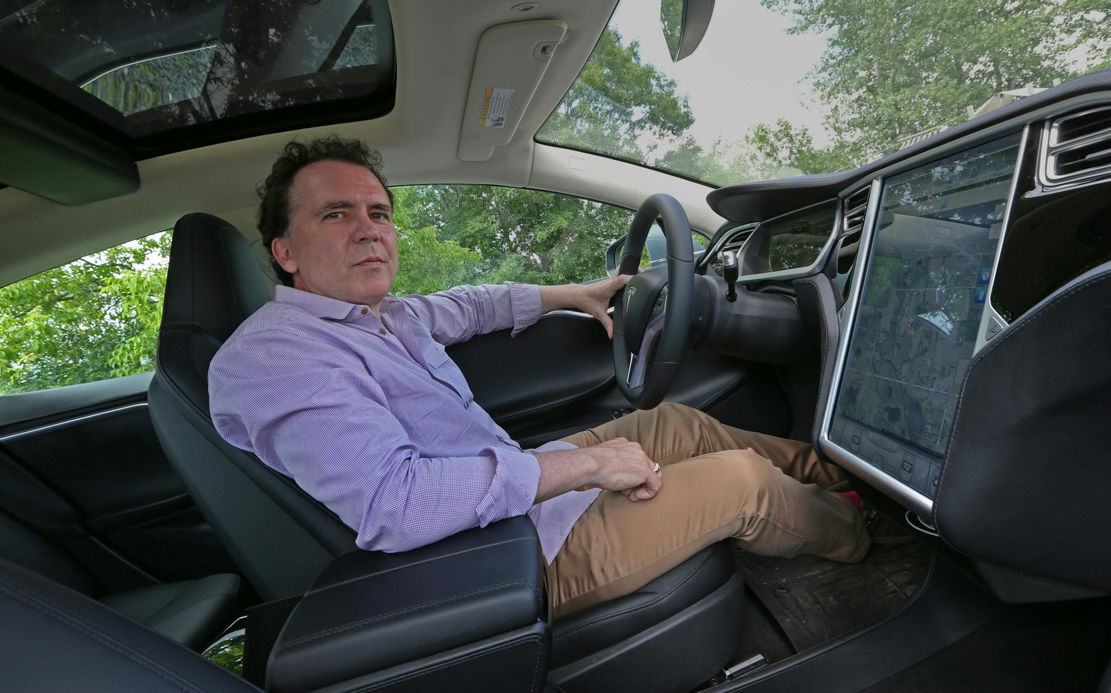 Shawn Otto, of Marine on St. Croix, showed off the touch-screen navigation system and ample space inside his Tesla Model S, a high-end electric vehicle.