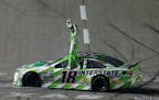 Kyle Busch stands on his car after winning the NASCAR Sprint Cup Series auto race at Texas Motor Speedway in Fort Worth, Texas, early Sunday, April 10