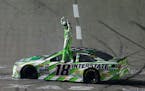 Kyle Busch stands on his car after winning the NASCAR Sprint Cup Series auto race at Texas Motor Speedway in Fort Worth, Texas, early Sunday, April 10