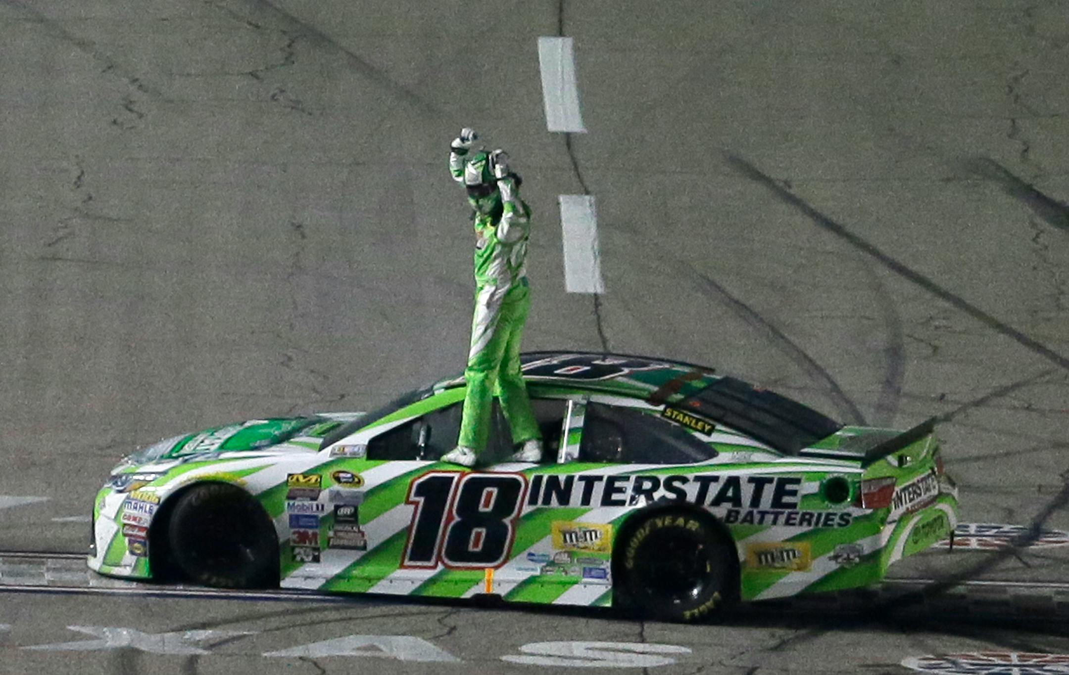 Kyle Busch stands on his car after winning the NASCAR Sprint Cup Series auto race at Texas Motor Speedway in Fort Worth, Texas, early Sunday, April 10, 2016. AP Photo/Tim Sharp)