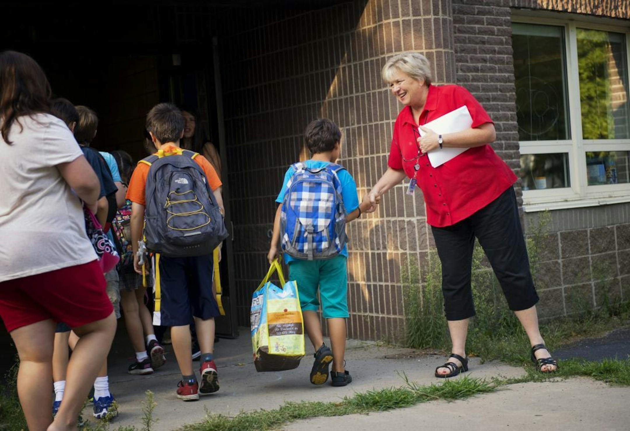 Marcy Open School principal Donna Andrews greeted students on the first day of classes in Minneapolis. Monday, August 26, 2013