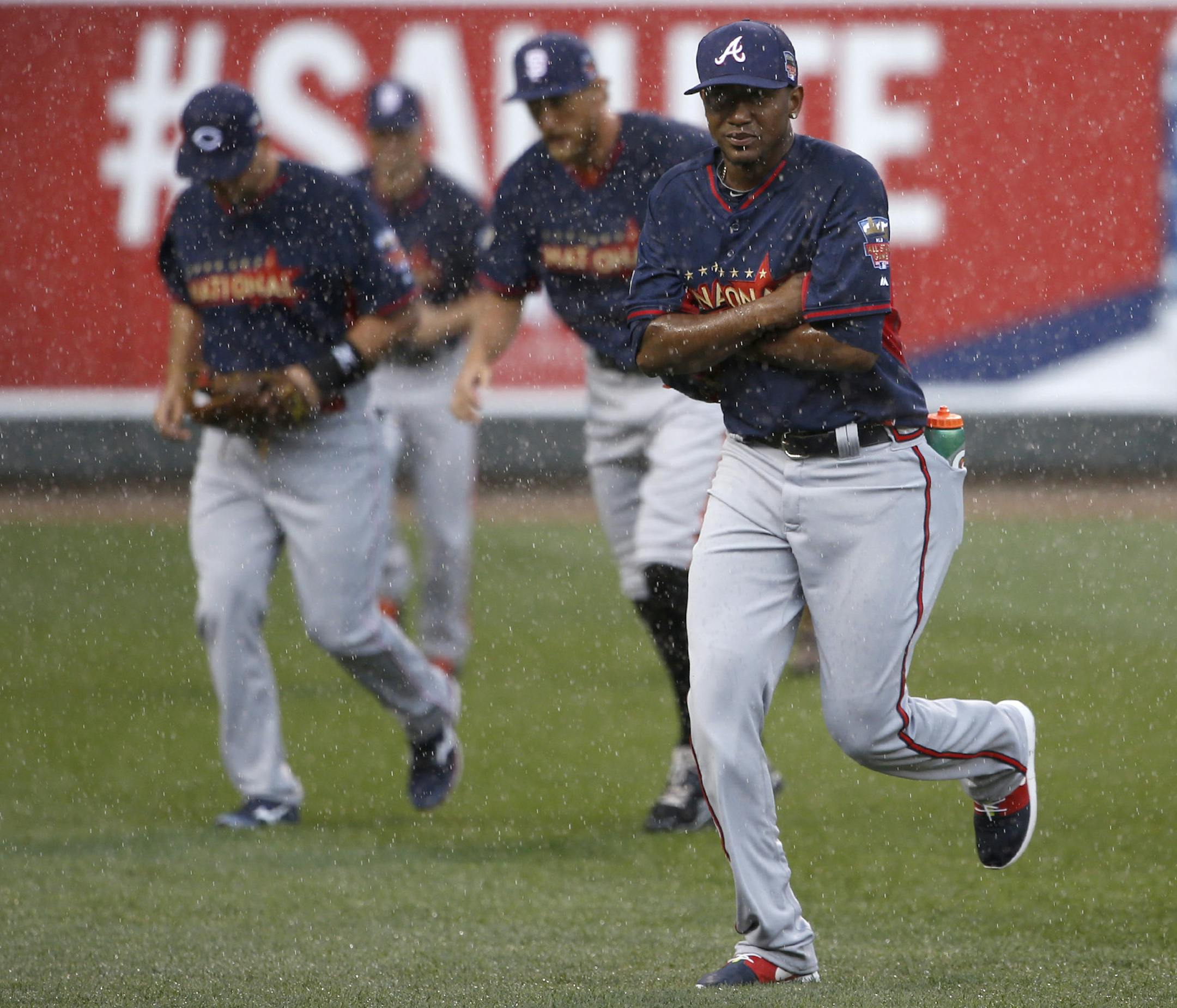 The national league players head for cover as rain started up again during batting practice before the Home Run Derby. ] CARLOS GONZALEZ cgonzalez@startribune.com - July 14, 2014 , Minneapolis, Minn., Target Field, All Star Home Run Derby