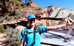 Katie Burns, in Zion National Park, holding a primary feather of a California condor.