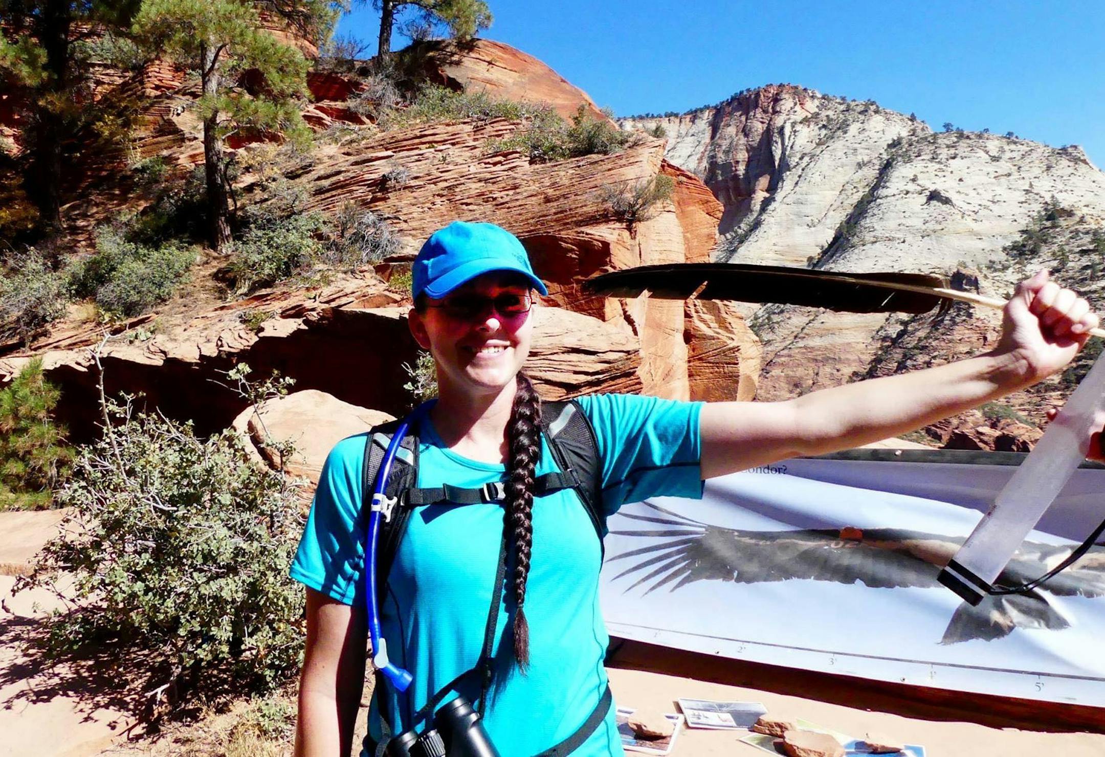 Katie Burns, in Zion National Park, holding a primary feather of a California condor.